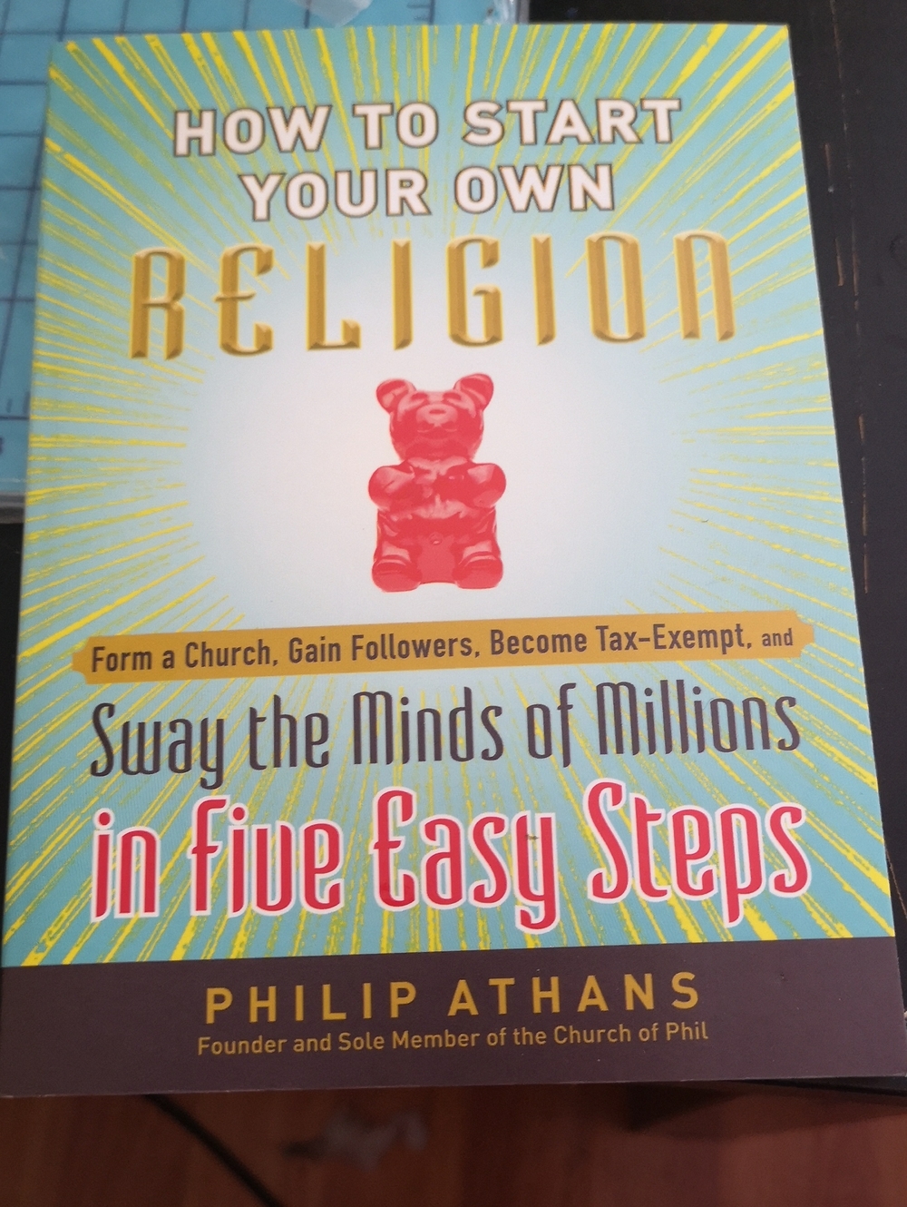 How to Start Your Own Religion by Philip Athans - Teal & Yellow Cover